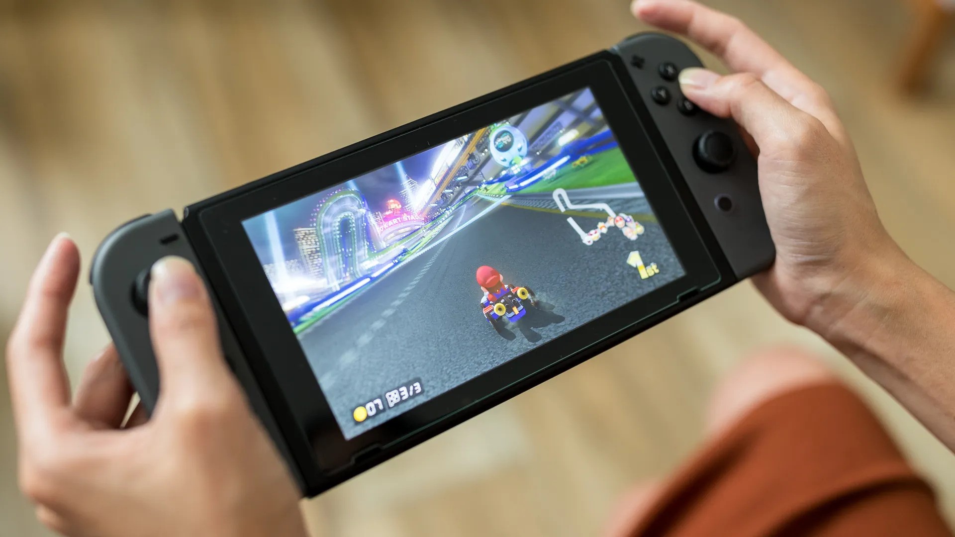 Someone playing Mario Kart on the Nintendo Switch in handheld mode.